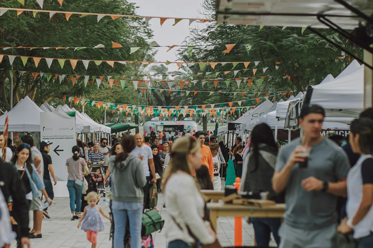 Une fête locale : des stands d’associations sous des guirlandes de fanions